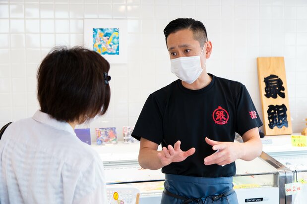 Morita explains to a customer how to prepare and cook the recommended fish of the day.
