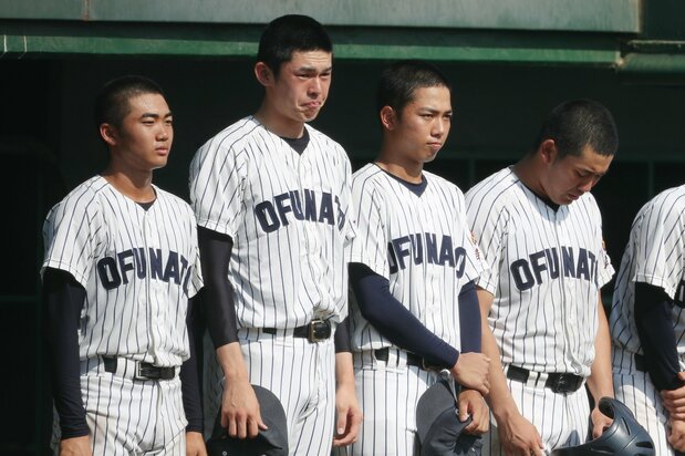 Sasaki Rōki, second from left, and other members of the Ōfunato team hold back tears following their loss to Hanamaki Higashi in the final game of the Iwate prefectural tournament on July 25, 2019. (© Jiji)