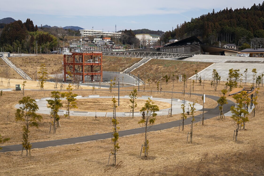 国道45号から旧防災対策庁舎を望む。手前の植樹が並ぶエリアは「みらいの森」で、奥には中橋や南三陸311メモリアルが見える