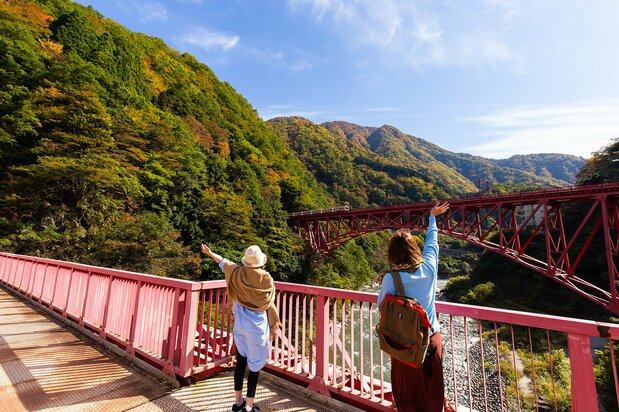 Sightseers wave to the train crossing the Shin-Yamabiko Bridge.