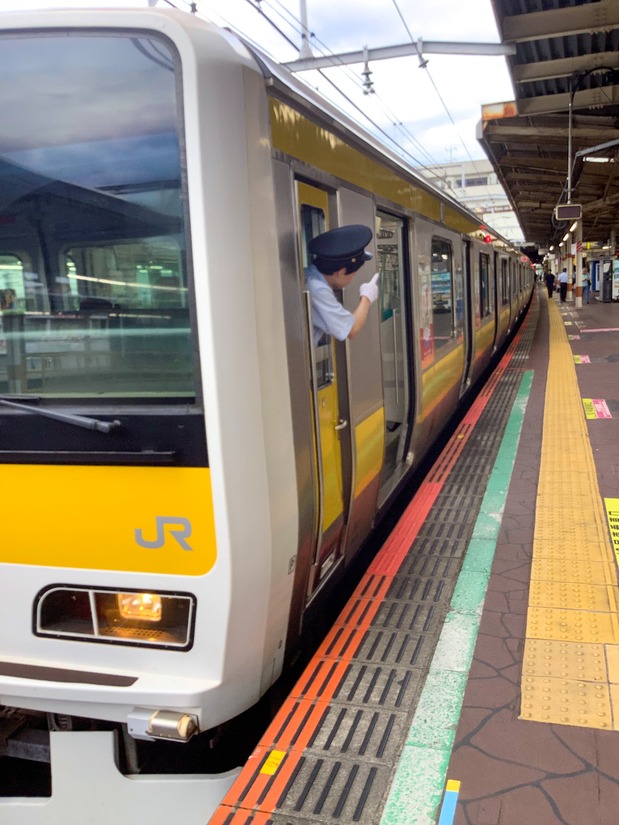 Un revisor procede a corroborar el estado de apertura de las puertas mediante el shisa kanko. (Cortesía de JR East Japan)