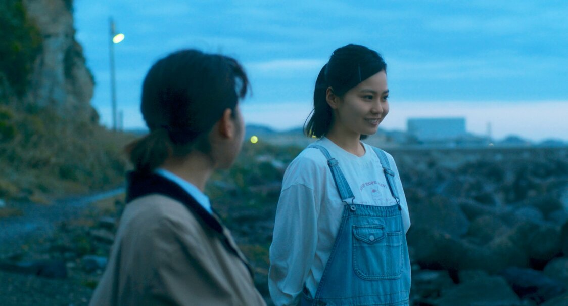 真奈は明け方の海を見ながら、祥栄の娘の羽純（新谷ゆづみ・右）に童歌を歌ってもらう ©2022 映画「やがて海へと届く」製作委員会