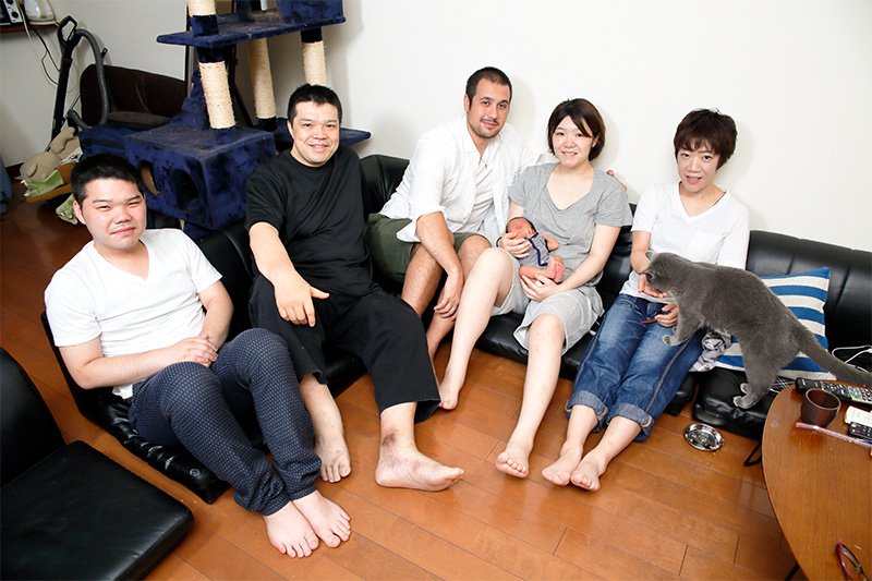 Corey y Ryō posan con su bebé y la familia de ella en Tokio. En el hogar de los Katō es tradición independizarse en los dos años transcurridos tras finalizar los estudios. A la izquierda, el hermano pequeño de Ryō, que ya no vive en la casa. Al lado de él, su padre, que trabaja como quiropráctico. A la derecha, su madre, que es enfermera. Ambos proceden de Hokkaidō.