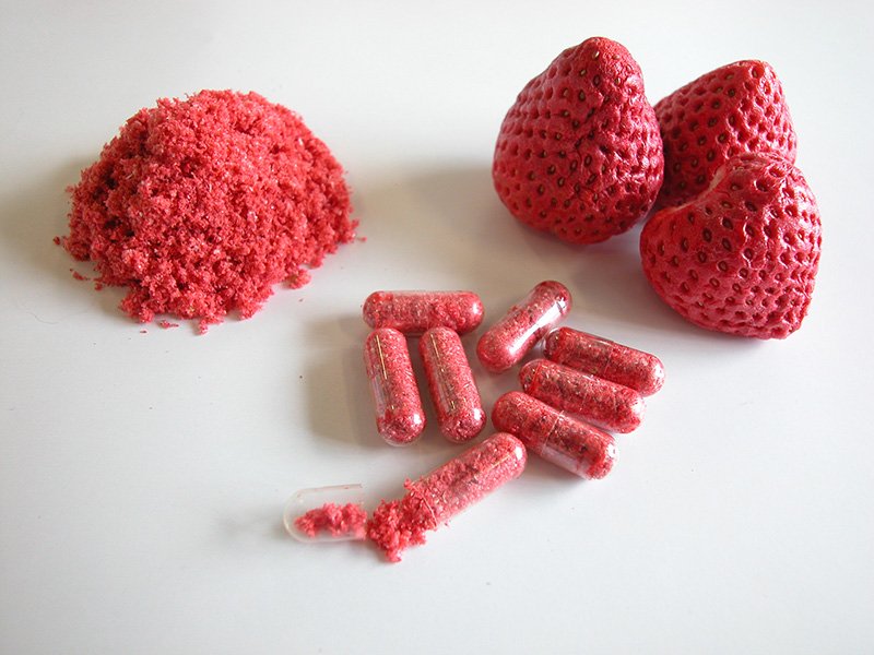 Fraises contenant l'interféron canin, et pilules finales (image conceptuelle).
