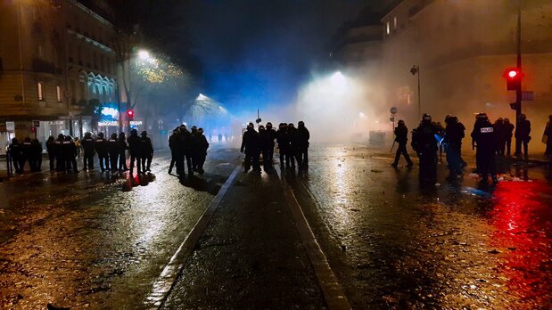 白煙が青い照明と赤信号で照らされ三色旗のようだ。だがフランス共和国が掲げる「自由・友愛・平等」はいずこ? © Le Bureau - Jour2Fête – 2020