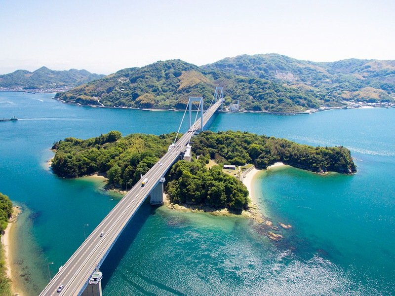 El gran puente Hakata-Ōshima visto desde Hakatajima. Michikajima, en el centro, está conectada con ambos lados por un puente de vigas y un puente colgante