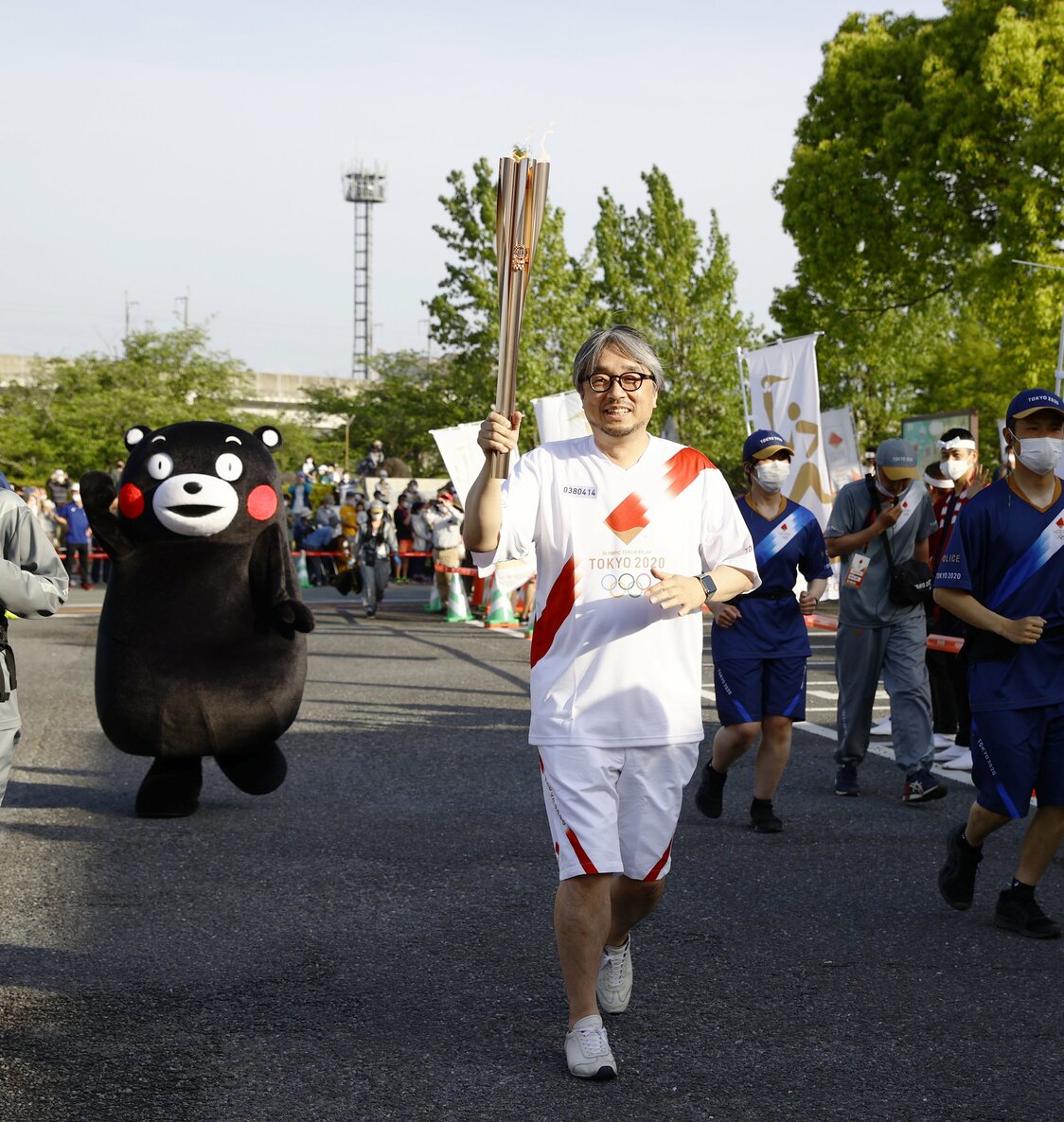 東京五輪の聖火ランナーを務める放送作家の小山薫堂さん。くまモンの生みの親だ。左後方をくまモンが走る＝2021年5月5日、熊本県宇土市（時事）