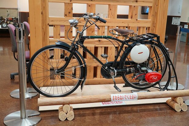 1952年にホンダが発売した自転車用補助エンジン「カブF型」。白いタンクと赤いエンジンで広く親しまれた(筆者撮影)