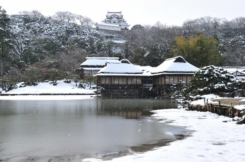 從雪中的大名庭園(江戶時代諸侯建造的私家庭園──譯註)——玄宮園,遠望彥根城的天守閣