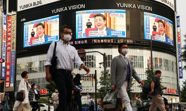 Screens in Shinjuku, Tokyo, report the lifting of the state of emergency on May 25, 2020. (© Jiji)