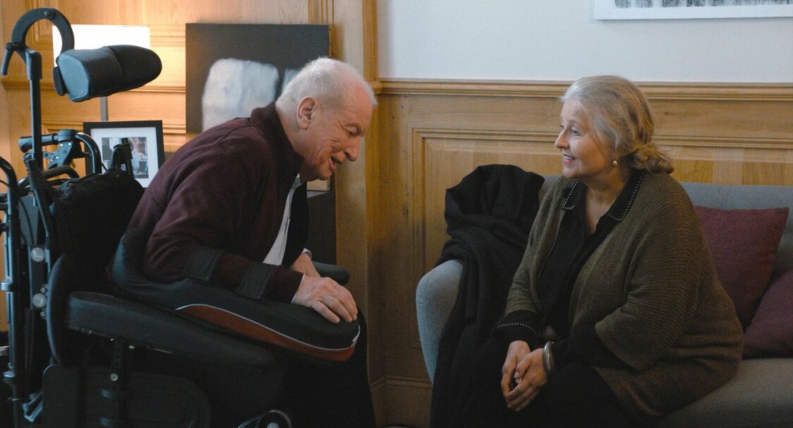スイスの協会から担当者（ハンナ・シグラ）が面会に訪れる　© 2020 MANDARIN PRODUCTION – FOZ – France 2 CINEMA – PLAYTIME PRODUCTION – SCOPE PICTURES