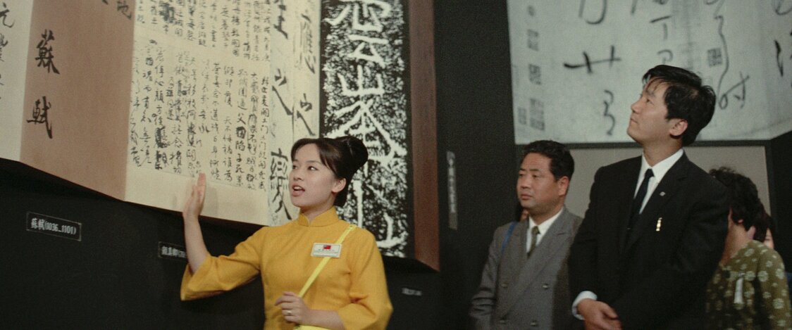 台湾パビリオンの内部を案内するコンパニオンの雪子　© 2025 Taiwan Film and Audiovisual Institute. All rights reserved.