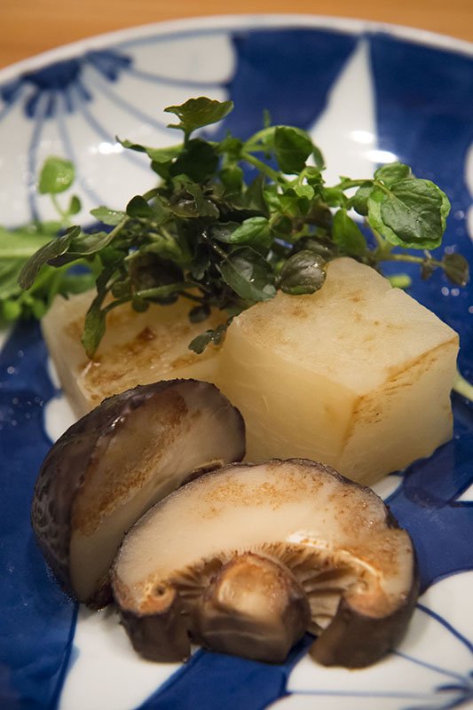 Rábano cultivado al aire libre, brotes de hoja de rábano y setas shiitake carnosas.