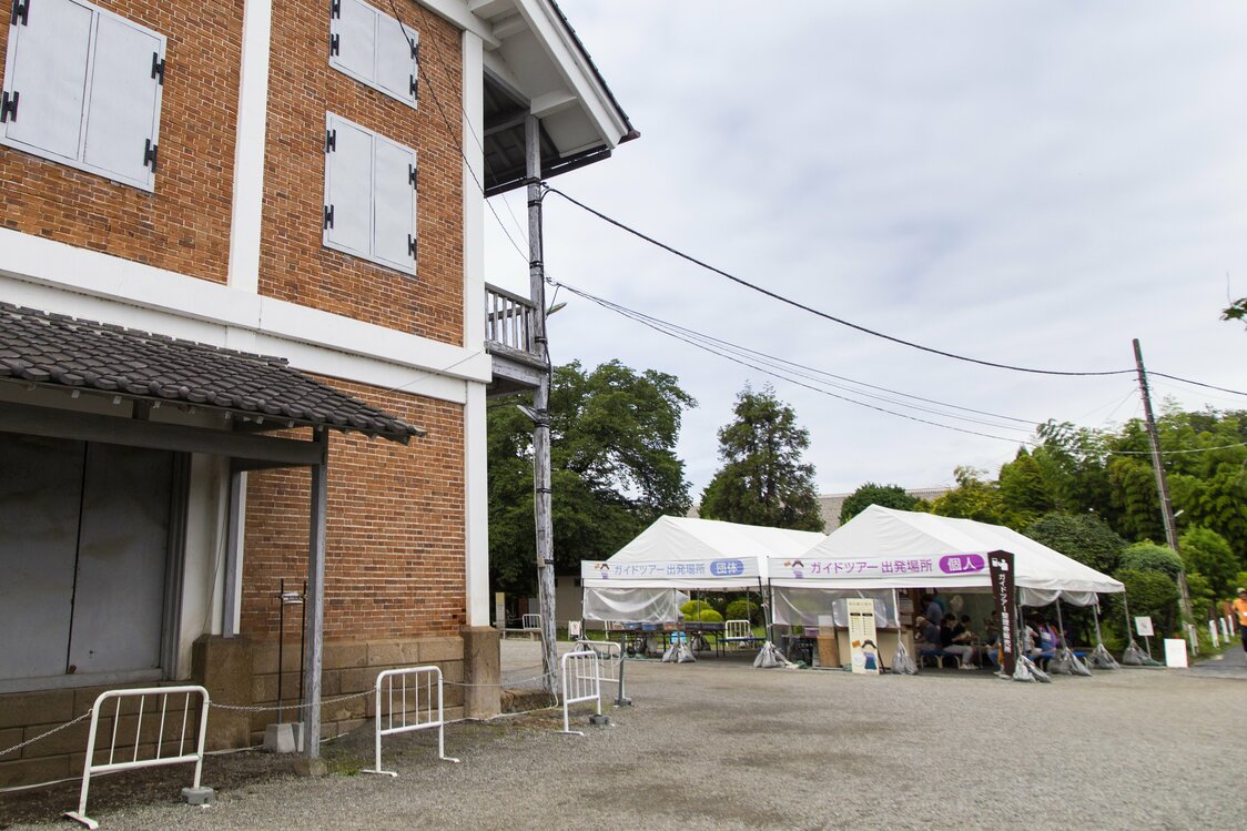 東置繭所の裏手にある「ガイドツアー出発場所」のテント。予約は必要ないが、開始時刻の30分前から整理券が販売されるので早めに手に入れよう