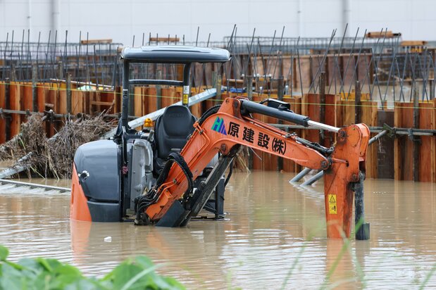 大雨の影響で冠水した重機 (富山県氷見市、時事)