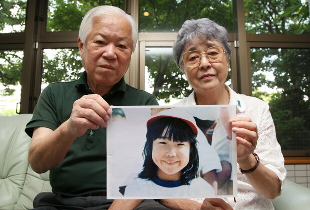 北朝鮮に拉致された横田めぐみさんの写真を持つ横田滋さんと早紀江さん夫妻(時事、2012年9月)