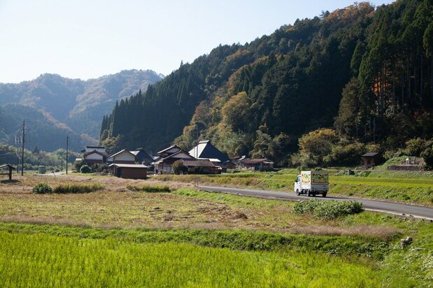 The arrival of the truck to each home along the route is signaled by loudspeakers playing a 2003 song about the famous sand dunes along the Tottori coast. (© Ōnishi Naruaki)