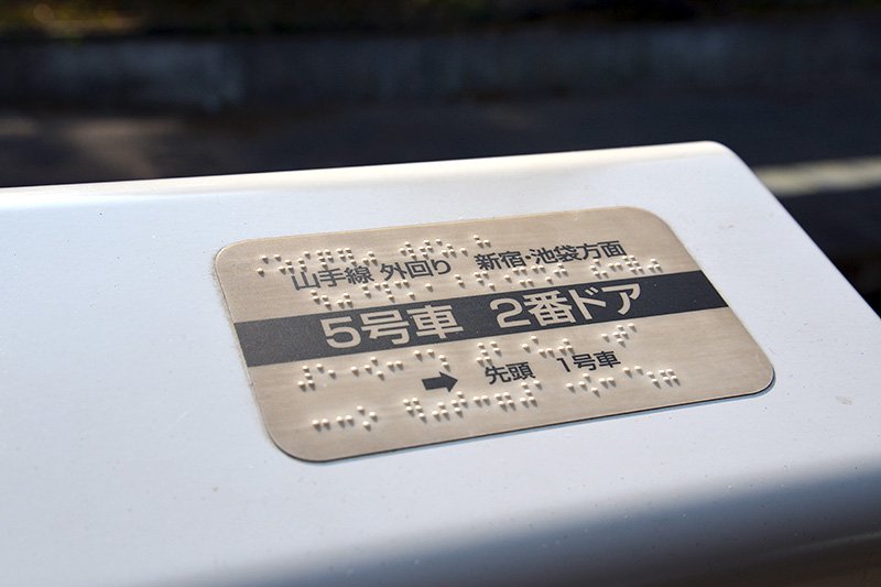 Une plaque sur une porte d’un quai fournissant de l’information en braille.