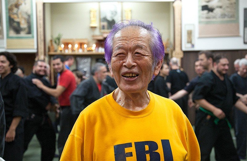 米FBIからプレゼントされたという黄色のトレーナーの背中には「SOKE」（宗家）の文字がプリントされている。紫色に染めた髪は「妻から勧められたから」と、初見氏は笑みを絶やさない