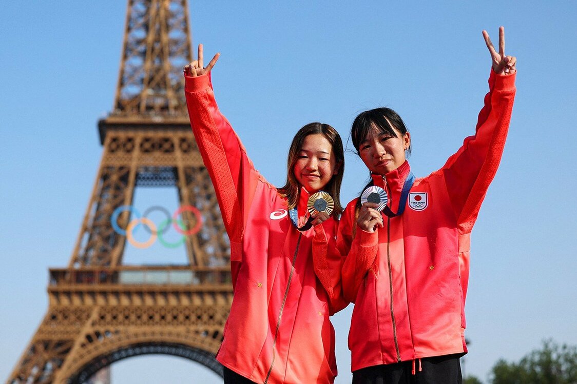 スケートボード女子ストリート金メダリストの吉沢恋（ここ）(左）と銀メダリストの赤間凛音（りず）。14歳の吉沢と15歳の赤間がワンツーフィニッシュし、日本は2大会連続で複数メダルを獲得した。エッフェル塔前のチャンピオンズパークでメダルを手にポーズをとった（ロイター）