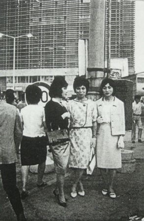 Members of the secret cross-dressing club Fuki posing for a photo in front of the refurbished Shinjuku Station building in June 1964.