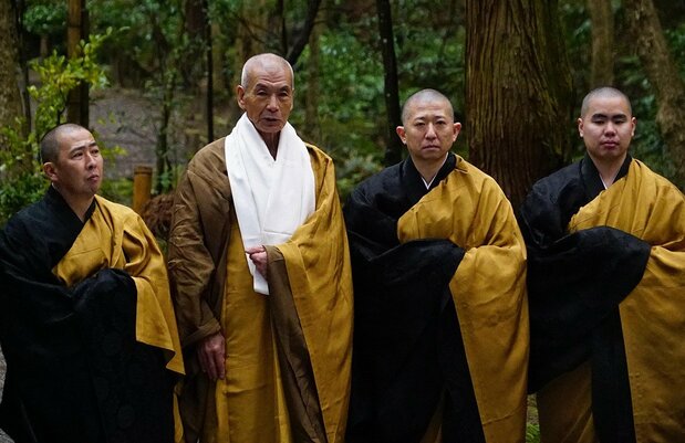 同。断食修行をやり遂げ、桜町領へと戻る金次郎を見送る成田山新勝寺の僧侶たち。貫主の照胤を田中泯が演じた(© 映画「二宮金次郎」製作委員会)