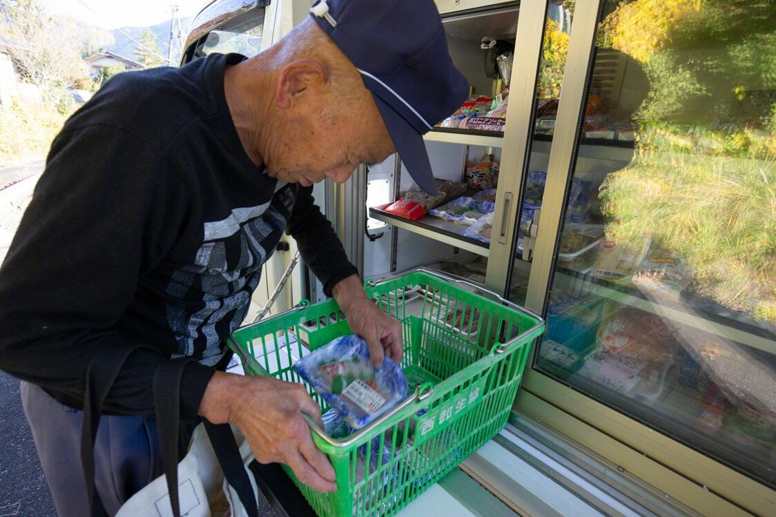 「移動販売車の来る日が楽しみ」刺身のパックを次々と籠に入れる