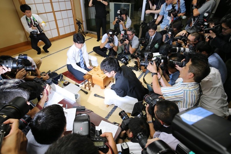 Fujii, in shirtsleeves, faces an unprecedented number of media photographers along with his opponent, Masuda Yasuhiro, in the June 26 match that would be his twenty-ninth consecutive win. (© Jiji)