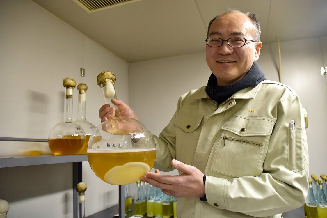 県オリジナルの酵母を手にする工業技術センター食品醸造技術部研究員の石垣浩佳さん。建物内には精米機や酒造設備、麹室も備え、時には泊まり込みで試験醸造を行っている