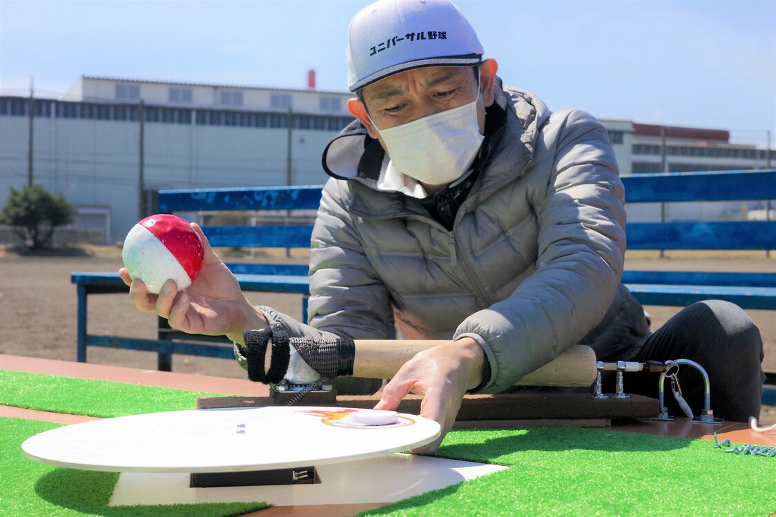 Nakamura ajustando el plato giratorio, la pieza clave del Béisbol Universal. (Fotografía del autor)