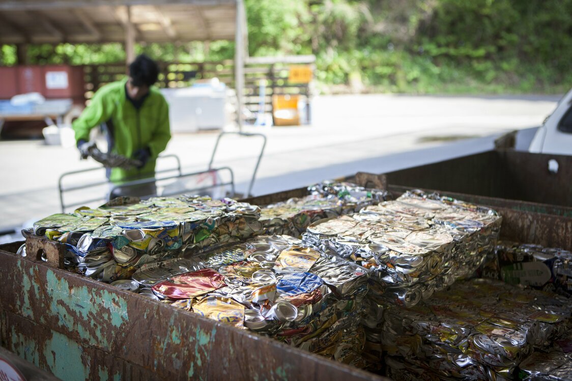 Les boîtes de conserve et canettes sont compactées par une machine appelée CANPECO, qui produit des blocs d’aluminium à encombrement réduit.