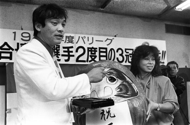 3年ぶり2度目の三冠王を達成し、信子夫人と喜ぶ落合博満選手(時事)