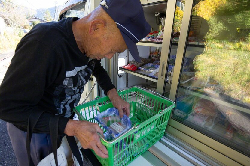 「移動販売車の来る日が楽しみ」刺身のパックを次々と籠に入れる