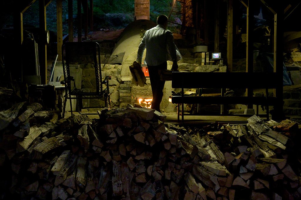 Putting more wood into the kiln—a process that lasts two weeks.
