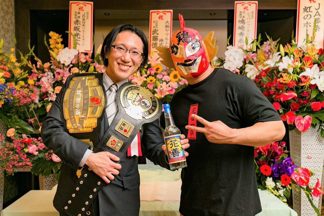 5代目社長・花岡ウタさんの孫、八木橋秀一さん（45）は東京生まれの東京育ち。フリーターをしていた20歳の時、ウタさんから「東京に支店を出すから1年間大館で修業しなさい」と言われてやって来て、以来ずっと大館暮らしが続いている。プロレス団体で働いていたこともあり、肩にかけたチャンピオンベルトは「駅弁大将軍」受賞を記念してつくったもの。　写真提供：花善