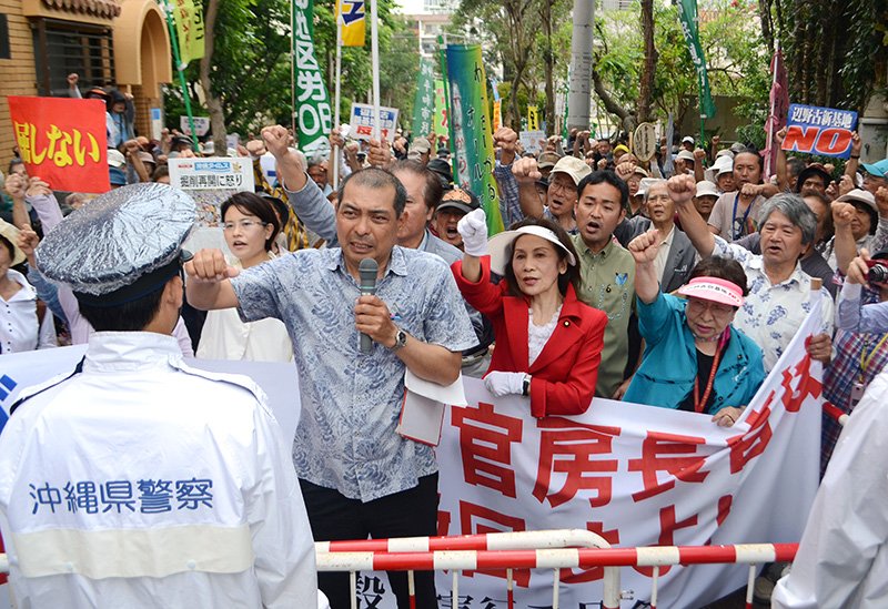 沖縄県の翁長（おなが）雄志知事と菅義偉官房長官が会談するホテルの前で、「辺野古新基地建設を撤回せよ」などと抗議の声を上げる県民ら　©時事