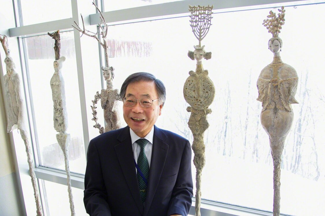 El director Hirado, que trabajó para la fundación del Consejo, posa con obras de Yamamoto Makoto que son patrimonio cultural del pueblo.