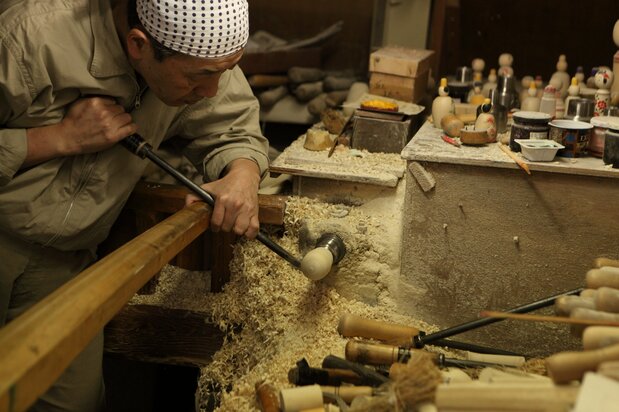 Un artisan de l’atelier « Sakurai kokeshi-ten » en train de sculpter une poupée. Dans cet endroit situé dans la station thermale de Naruko, les clients ont la possibilité de décorer eux-mêmes leur kokeshi au pinceau.