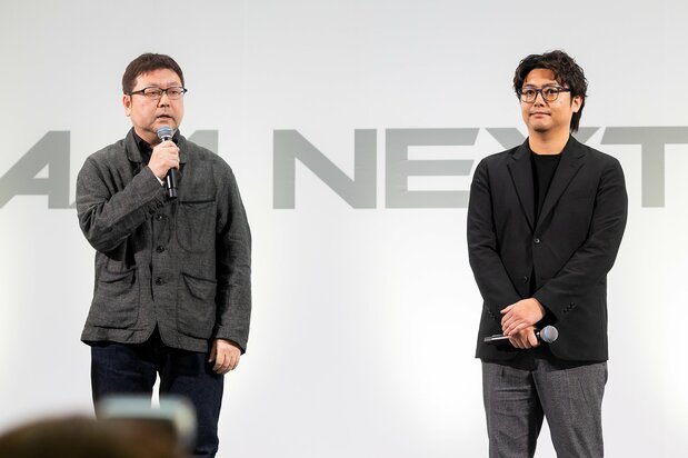 Новый видеоролик был представлен на мероприятии «GUNDAM NEXT FUTURE -FINAL-», которое проходит в токийском районе Синдзюку до 24 числа. Слева - режиссёр Цудзимото Таканори, справа - продюсер Морисита Кентаро (Bandai Namco Filmworks).