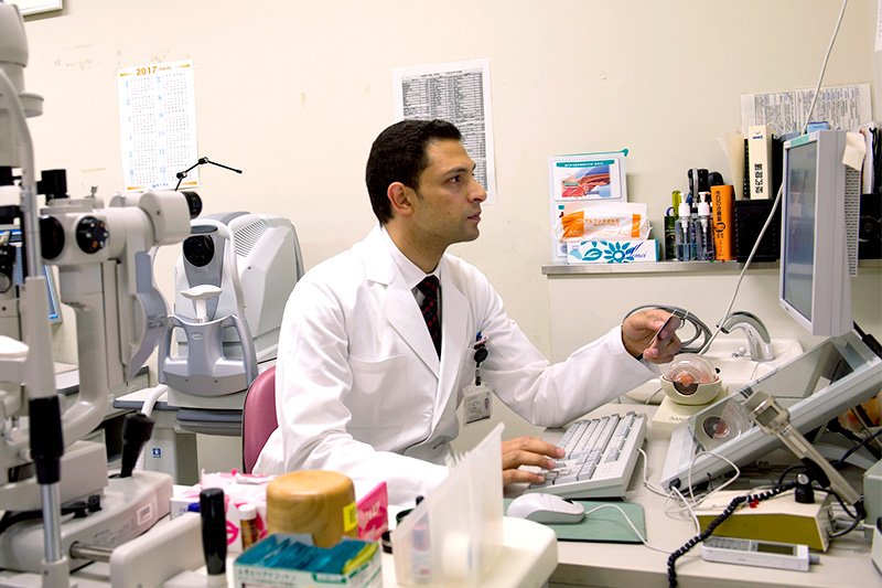 دكتور أسامه يراجع نتائج الكشف على أحد المرضى في عيادته بمستشفى جامعة طوكيو.