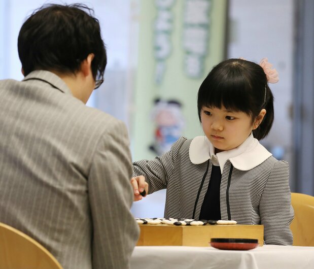 井山裕太5冠(手前)と対局する小学4年生の仲邑菫さん=2019年1月6日、大阪府東大阪市(時事)