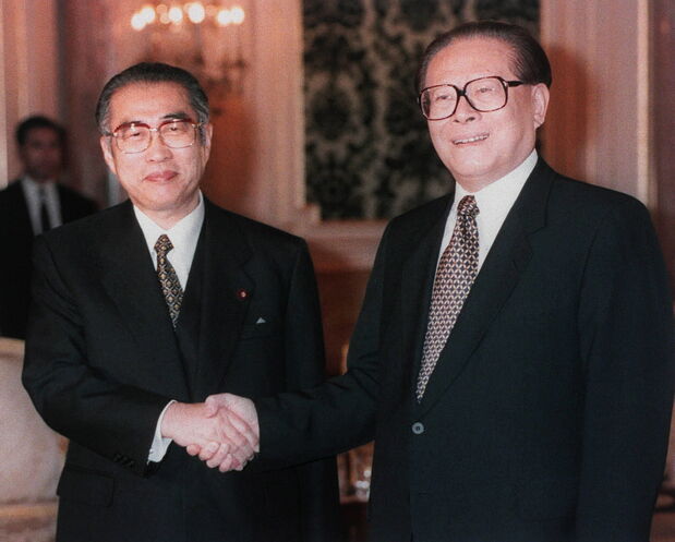 日中首脳会談を前に握手する小渕恵三首相（左）と江沢民中国国家主席（東京・元赤坂の迎賓館）［代表撮影］　（時事）