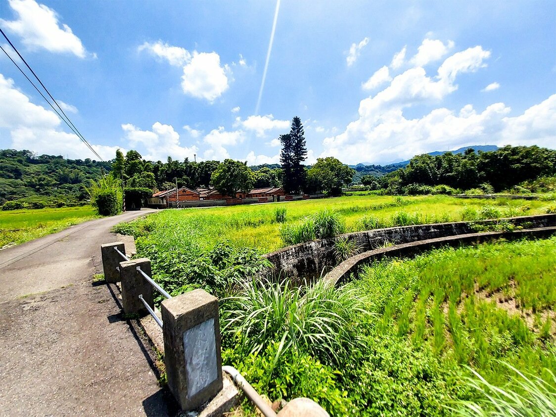 用水路の橋の向こうに「永安居」、その後ろの山を越えれば「慈湖」のある草嶺山がある