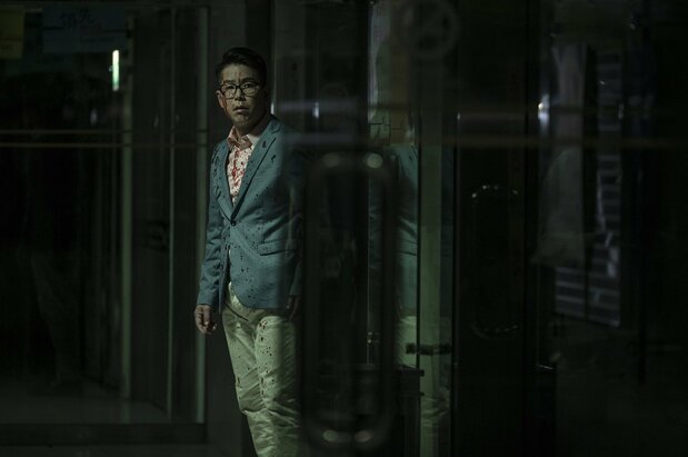 主人公のひとり、投資系配信者ヨン・ワイ。血まみれの姿には理由がある ©2021 Media Asia Film Production Limited, Movie Addict Productions Limited All Rights Reserved