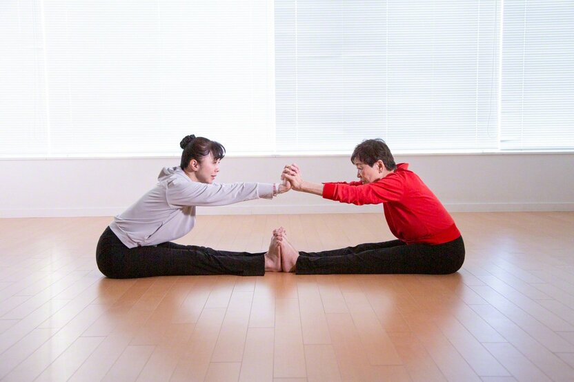 To start with, two people sit opposite each other and join their fingers and toes together. Getting a tactile “feel” for the other person is important. (© Ōnishi Naruaki)