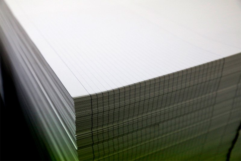 A stack of notebook paper ready for binding.