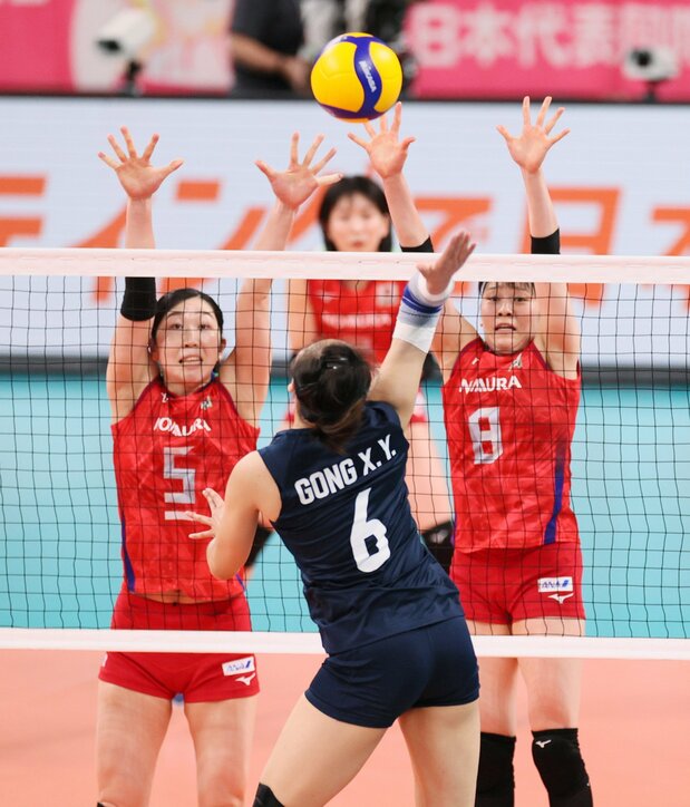 Araki (left) goes for a block during a friendly match against China at the Ariake Arena in Tokyo on May 1, 2021. At 186 centimeters tall, she is a key player at the net for the Japanese national team. (© Jiji)