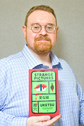 『Strange Pictures』を手にする『変な絵』英訳者、ライオン・ジミーさん(筆者提供)