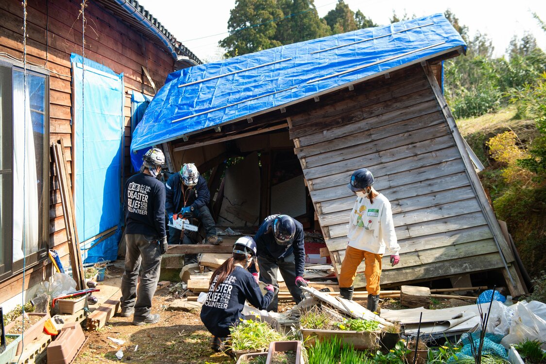 納屋が崩れないように川島さんたちが応急処置し、学生たちが中の荷物を運び出す