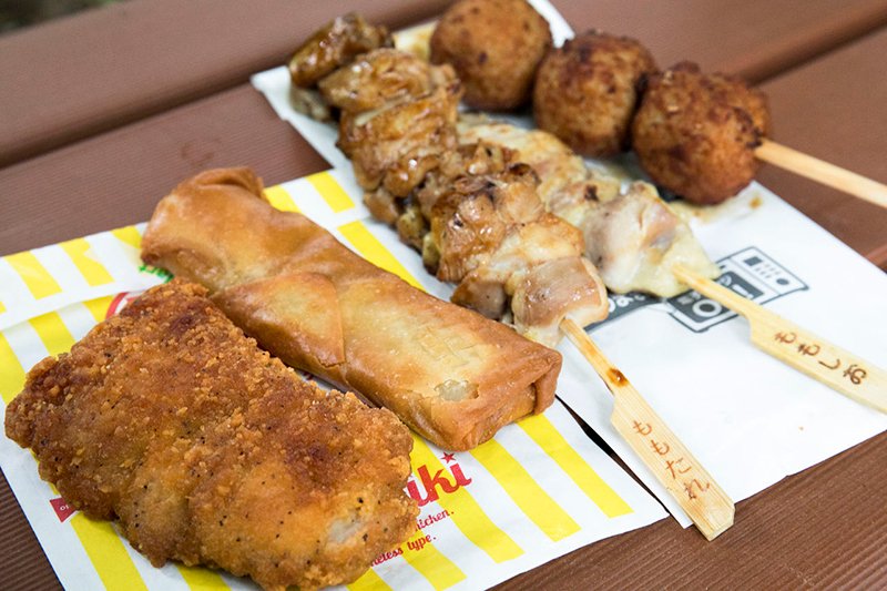 熟食小吃不仅可以果腹，也是最好的下酒小菜。左起“全家炸鸡”“春卷”，右侧是热销的“炭火烤鸡串”